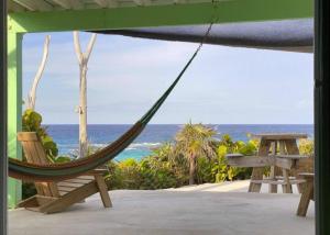 a hammock on a patio with a view of the ocean at Serenity - Away From The Things Of Man... Lat23N.c in McKanns