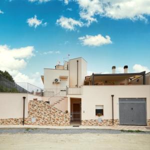 a white house with stairs and a blue sky at Casa Chersonnesus in Teulada