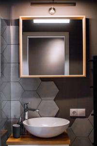 Modern apartment in Old Riga with a river view في ريغا: حمام مزود بحوض ومِرآة