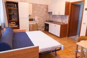 una pequeña cocina con una cama azul y blanca en una habitación en Casa Federica, en Molina di Ledro