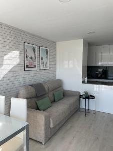 uma sala de estar com um sofá e uma cozinha em Apartamento Paradis Playa em La Pineda