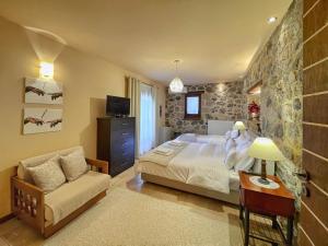 a bedroom with a king sized bed and a couch at Ocazzia of Parnassos in Polydrossos