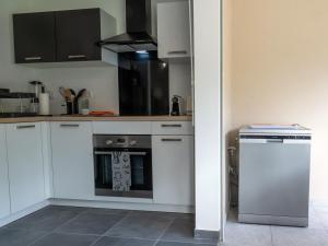 a kitchen with white cabinets and a stove top oven at Le Paradis Bleu in Les Trois-Îlets