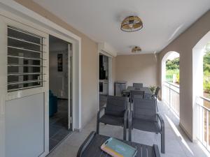 a room with chairs and tables and a balcony at Le Paradis Bleu in Les Trois-Îlets