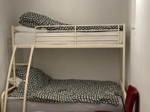 2 Etagenbetten in einem kleinen Zimmer mit einem Stuhl in der Unterkunft NAGYGÓLYA Appartementen in Szentistván