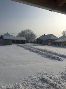 eine schneebedeckte Straße vor den Häusern in der Unterkunft NAGYGÓLYA Appartementen in Szentistván