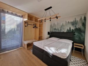 een slaapkamer met een bed en een groot raam bij Panorama Lofts Pec in Pec pod Sněžkou