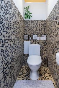 a bathroom with a toilet and a tiled wall at Pae 52 Apartment, Free Parking ,Airport 2km in Tallinn