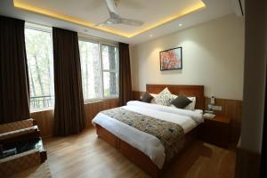 a bedroom with a large bed and windows at Alpviram Villa, 4 Bhk En-suite villa with elevator in Kasauli