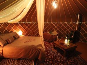 a bedroom with a bed and a table in a tent at The Warren Yurt in Withyham