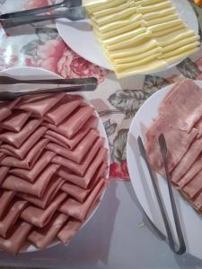 a table topped with plates of waffles and cheese at Chalé da Montanha in Serra Negra