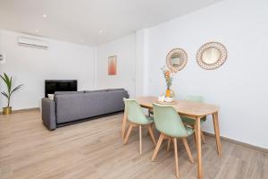 a living room with a table and chairs and a couch at Marmoles 21, City Center Apartment in Málaga
