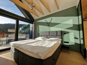 sypialnia z dużym łóżkiem i dużym oknem w obiekcie Panorama Lofts Pec w mieście Pec pod Sněžkou