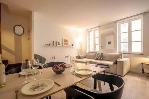 a living room with a table and chairs and a couch at Rare Appart 2 chambres en duplex design au Panier in Marseille