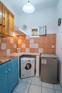 uma pequena cozinha com uma máquina de lavar roupa em Kontaratos Studios & Apartments em Parikia