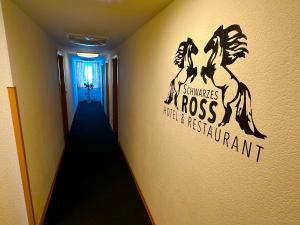 einen Flur mit einem Schild an der Wand in der Unterkunft Schwarzes Ross Hotel & Restaurant Oberwiesenthal in Kurort Oberwiesenthal