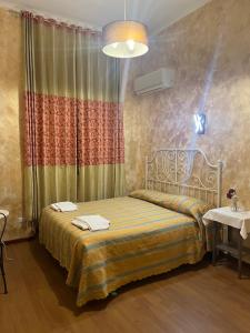 Rose Village Guest House في روما: غرفة نوم بسرير وستارة وطاولة