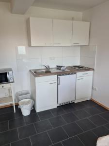 a kitchen with white cabinets and a sink at Wölfersheim-Berstadt in Wölfersheim +8 photos