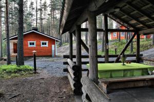 Cabaña pequeña con cama verde frente a ella en Kultajärven Loimu60, en Villala