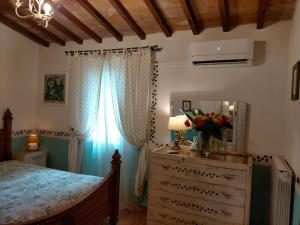 1 dormitorio con 1 cama y vestidor con espejo en Casale Eredità, en Orte
