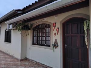 een huis met een deur en een raam bij Casa em Condomínio Martin de Sa in Caraguatatuba