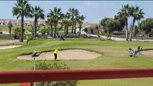 a man playing golf on a golf course at Agradable casa con piscina in Bolnuevo
