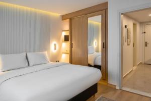 a bedroom with a white bed and a room with two beds at Parkside Boutique Serviced Apartments in Cairo
