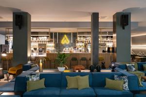 una hall con un divano blu e un bar di Arryvo Hotel a Lecce