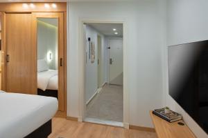ein Schlafzimmer mit einem Bett und einer Tür, die zu einem Flur führt in der Unterkunft Parkside Boutique Furnished Apartments in Kairo
