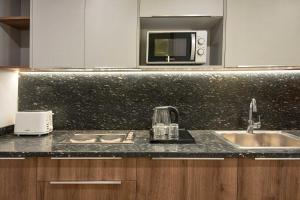 a kitchen with a sink and a microwave at Parkside Boutique Serviced Apartments in Cairo +46 photos