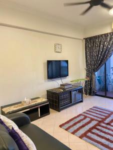 ein Wohnzimmer mit einem TV und einem Sofa in der Unterkunft Marina Cove, Lumut in Lumut