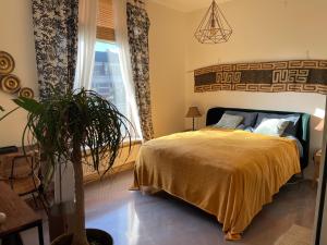 哈萊姆的住宿－Oase van Haarlem, 15 minuten van Amsterdam，一间卧室配有一张床和盆栽植物