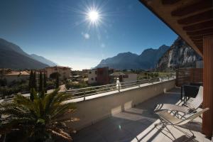 a balcony with two chairs and a view of mountains at Bertoldi Terme sul Garda - Terrazza in Nago-Torbole
