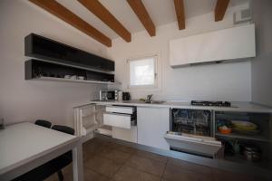 uma cozinha com balcões brancos e um balcão branco em Bertoldi Terme sul Garda - David em Nago-Torbole