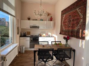 哈萊姆的住宿－Oase van Haarlem, 15 minuten van Amsterdam，小厨房配有桌椅和吊灯。