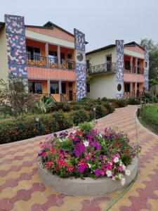 a building with a pot of flowers in front of it at Jungle Bell Resort in Lataguri