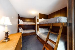 2 Etagenbetten in einem Zimmer mit einem Schreibtisch und einer Lampe in der Unterkunft Retreat on Rebecca in Killington