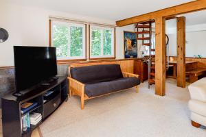 ein Wohnzimmer mit einem Sofa und einem Flachbild-TV in der Unterkunft Retreat on Rebecca in Killington
