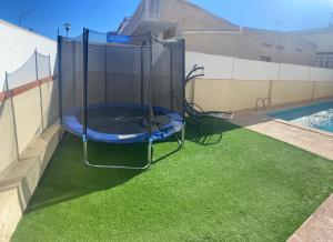 una piscina con una cama elástica en el césped en Casa con Gran Piscina particular cerca playa, en Torredembarra
