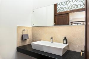 a bathroom with a white sink and a mirror at Lavish Executive Villa with Private Swimming Pool in Calangute