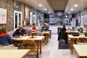 um grupo de pessoas sentadas em mesas em um restaurante em Camping Alta Ribagorça em El Pont de Suert