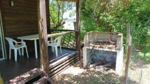 a patio with a grill and a table and chairs at • Cabaña Las Hortensias • in La Pedrera