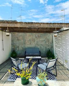 a patio with two chairs and a table and some plants at beddhra mia in Lecce