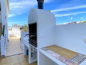 Biała kuchnia z piecem do pizzy na balkonie w obiekcie Villa Sandra Little Haven Apartment w mieście Nerja