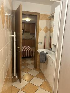 łazienka z drzwiami otwieranymi na umywalkę w obiekcie Appartamento Breva w Livigno