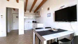 a living room with a television and a table with chairs at Bertoldi Terme sul Garda - Matthew in Nago-Torbole
