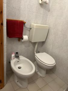 uma casa de banho com um WC branco e um lavatório. em B&B Il Nido em Riolunato