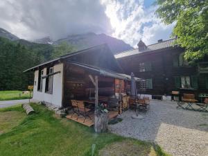 une cabane en rondins avec une table et des chaises en face de celle-ci dans l'établissement Berghotel Gasterntal, à Kandersteg