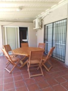 una mesa de madera y sillas en un patio en Disfrute y relax en Luján de Cuyo