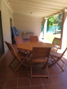 una mesa de madera y sillas en un patio en Disfrute y relax en Luján de Cuyo